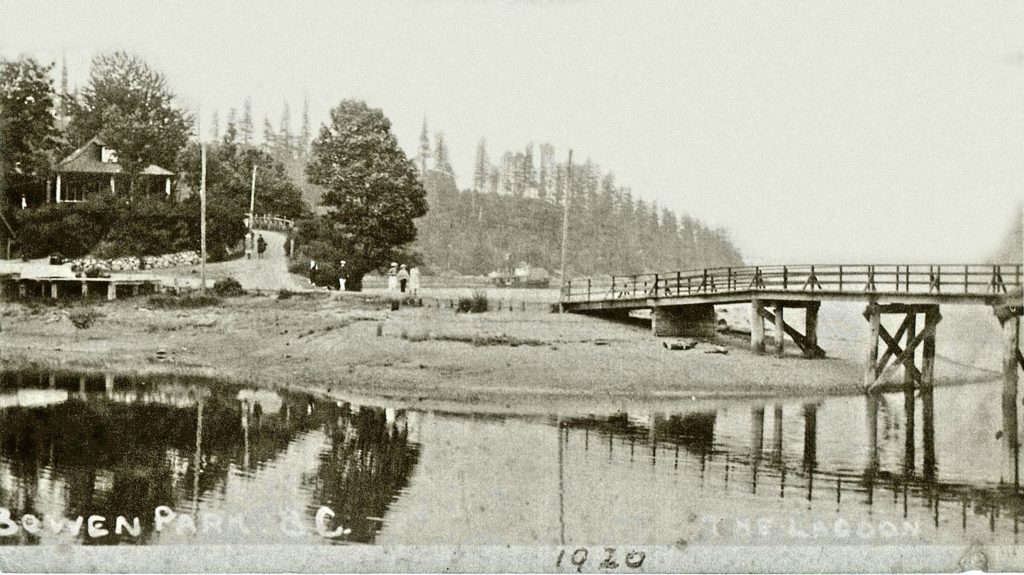 A wooden bridge crosses the lagoon where the causeway stands today, and at the end of it a wooden building.